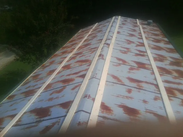 Rusted metal roof panels with new wood purlins before replacement — Storm Damage Roof Repair in Shattuck by Roofing Brothers
