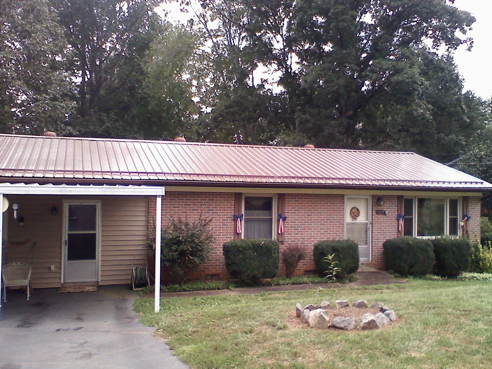 Bronze metal roof and carport on a brick ranch home — Roof Repair work by our crew in Shattuck